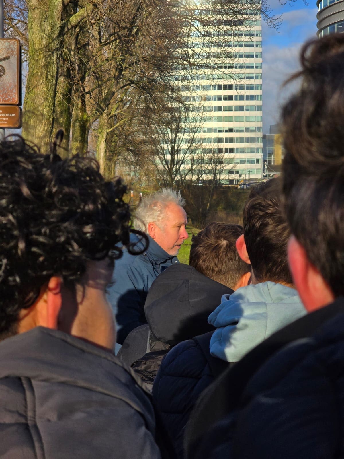 Kaj Munk College-leerlingen tijdens een excursie naar station Hoofddorp, waar ze het kunstwerk Moed! en de omgeving observeren om inspiratie op te doen voor hun ontwerpen.